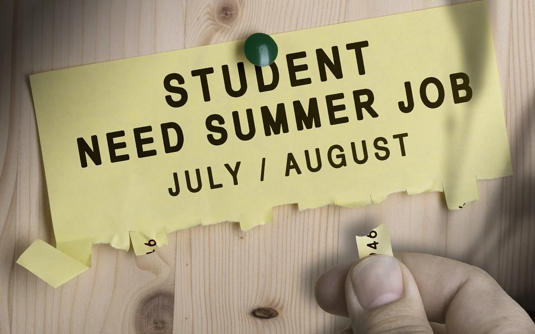 Yellow paper pinned on bulletin board with text: Student Need Summer Job July/August. Tabs with phone number have been torn off